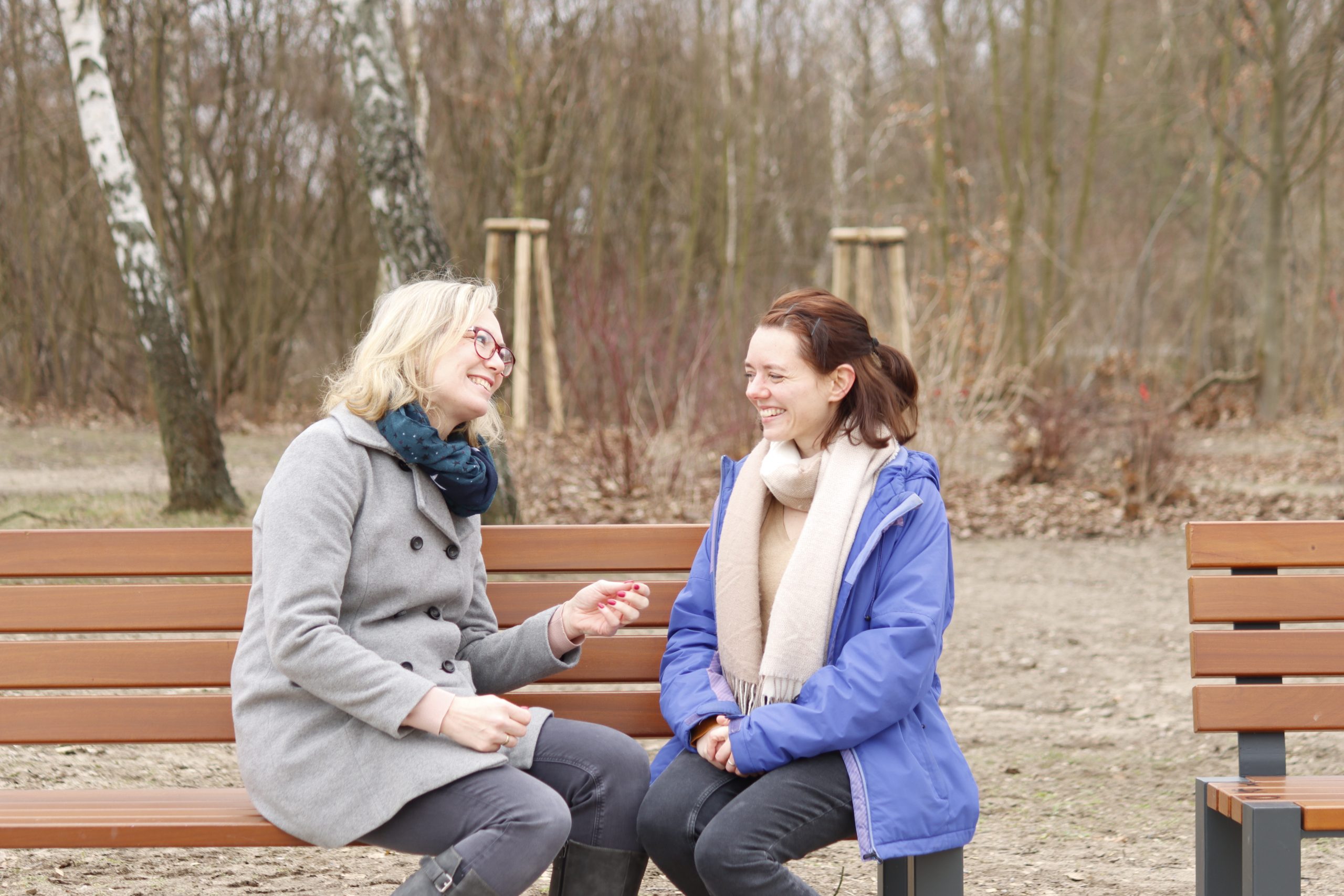 Anette Kluth und Nadine Schnittke sitzen auf einer Bank und unterhalten sich