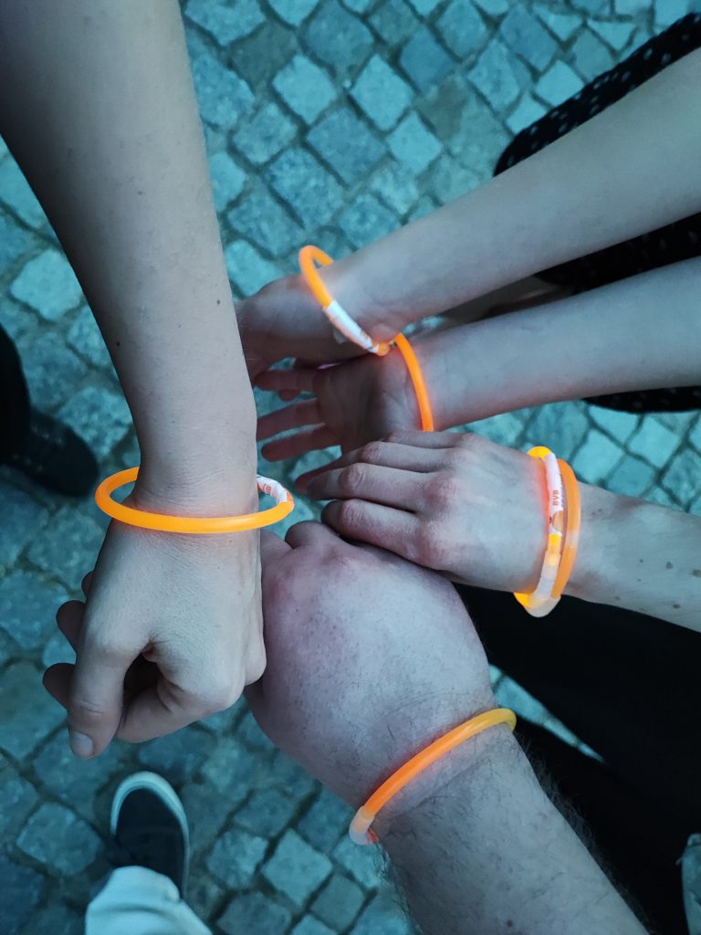 5 Hände mit orangen Knicklichtern