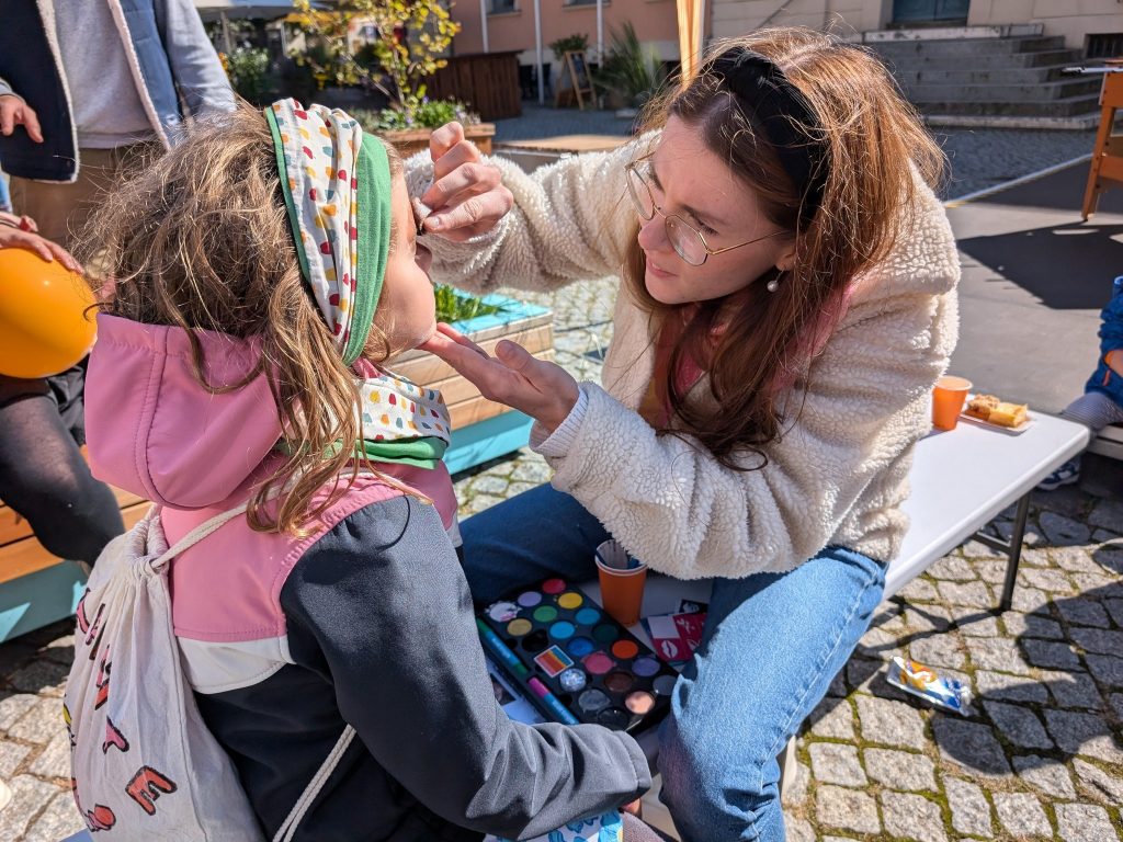 Helene Hermann schminkt ein Mädchen