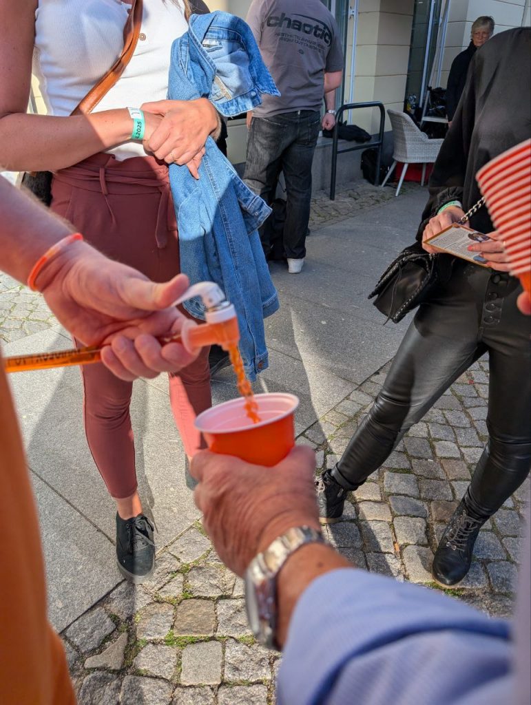 Orangensaft wird in einen Becher eingegossen