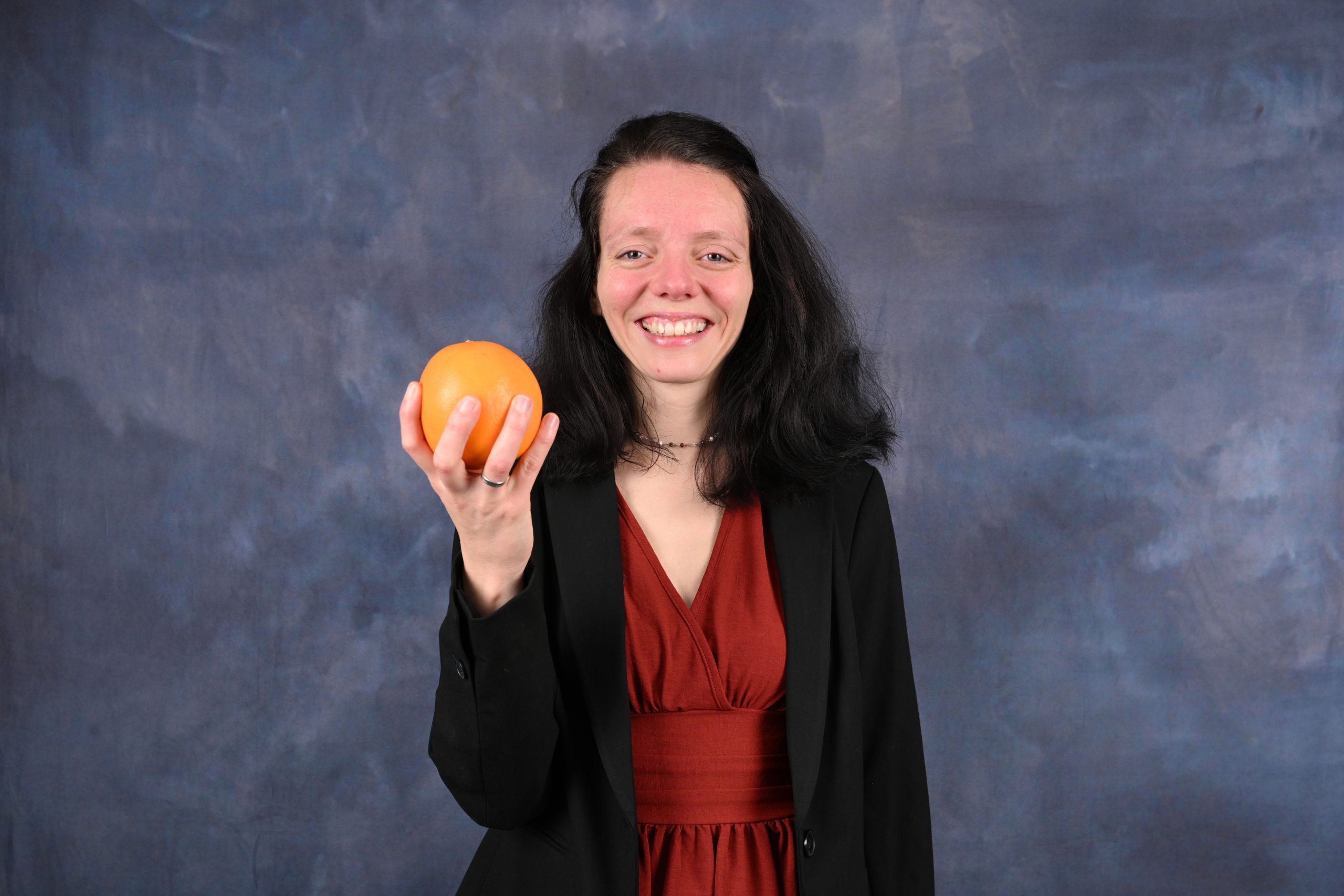 Nadine Schnittke mit Kleid und Blazer, Orange in der Hand