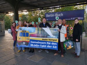 Mehrere Menschen am Bahnhof S Buch mit Banner
