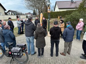 Nadine Schnittke und eine Traube von Menschen um Péter Vida im Blumenhag