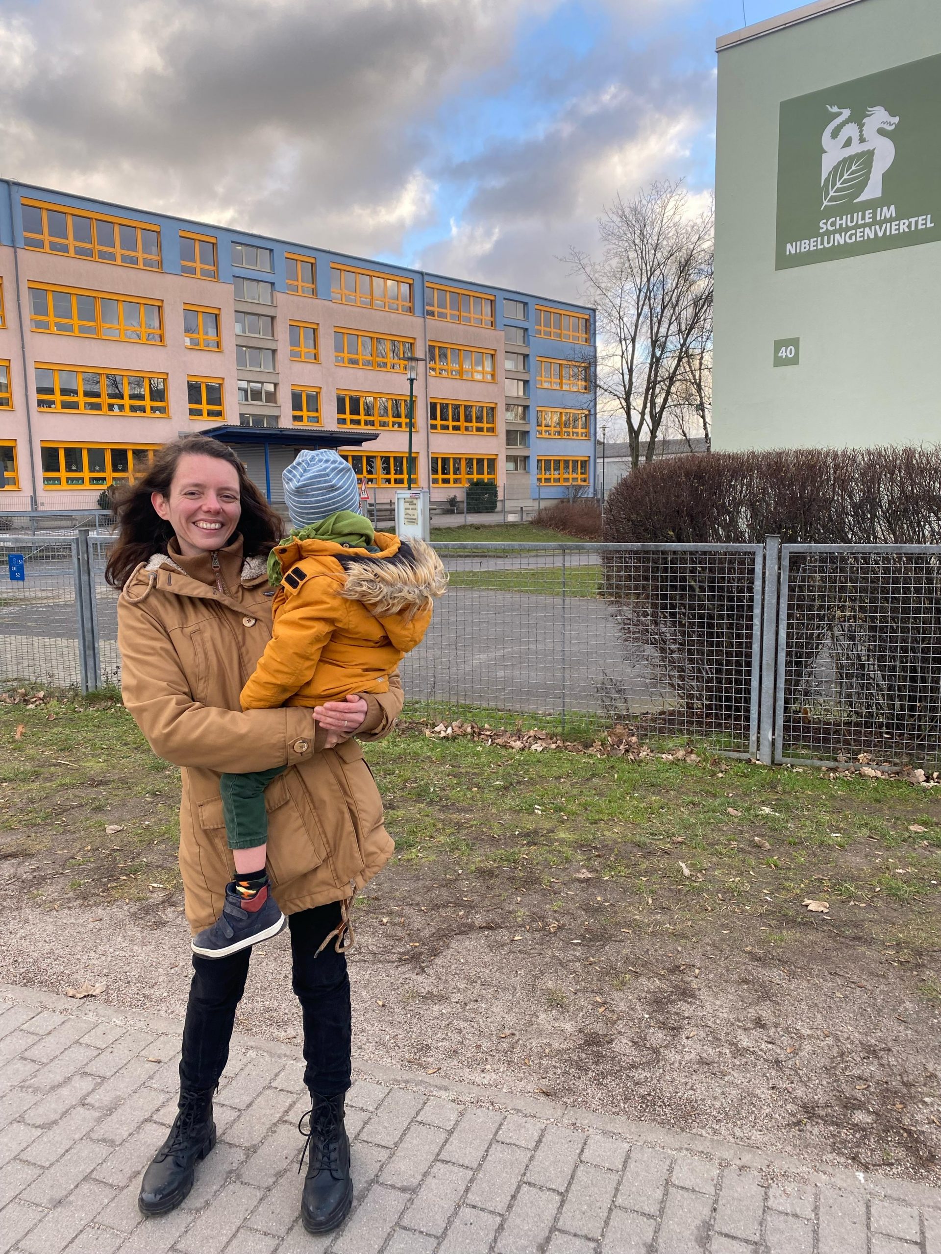 Nadine Schnittke und Kind vor einer Schule