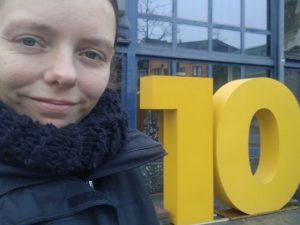 Nadine Schnittke neben großem Aufsteller mit einer 10 am Bahnhof